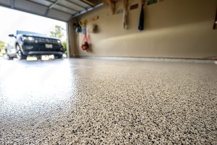 Garagenboden aus Epoxidharz. Auto fährt in die Garage.