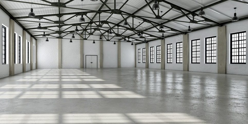 Große, helle Lagerhalle mit hellem Epoxidboden und vielen Fenstern.